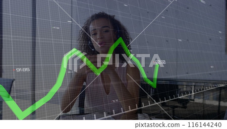 African American career woman wearing white tank top, standing by graph 116144240