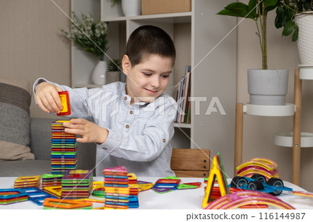 Boy building a tower from a magnetic construction set Boy building a tower from a magnetic construction set 116144987
