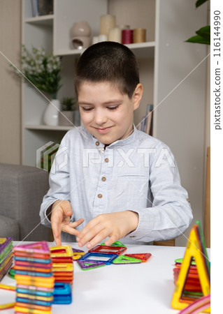 Boy builds buildings from a magnetic construction set Boy builds buildings from a magnetic construction set 116144990