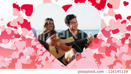 Image of hearts over happy caucasian friends with guitar on beach Image of hearts over happy caucasian friends with guitar on beach 116145139