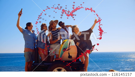Image of hearts forming heart shape over multiracial friends taking selfie against sea and sky Image of hearts forming heart shape over multiracial friends taking selfie against sea and sky 116145157