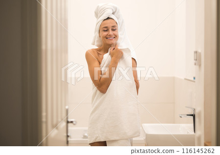 Slim young woman in white towel standing in the bathroom 116145262