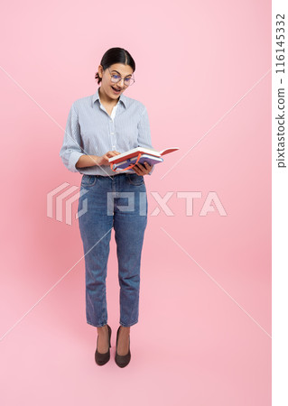 Full length of girl in casual shirt holding organizer reading information Full length of girl in casual shirt holding organizer reading information 116145332