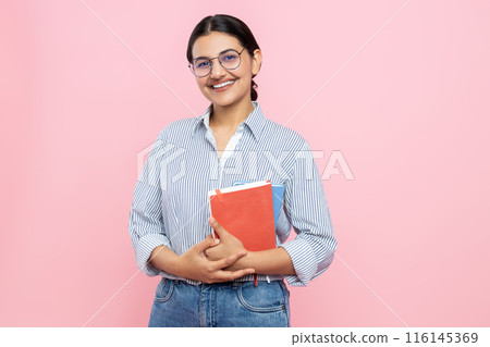 Cheerful delighted girl in casual shirt holding organizer with her notes Cheerful delighted girl in casual shirt holding organizer with her notes 116145369