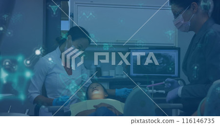 Caucasian doctor examining Asian child, with an Asian nurse assisting 116146735