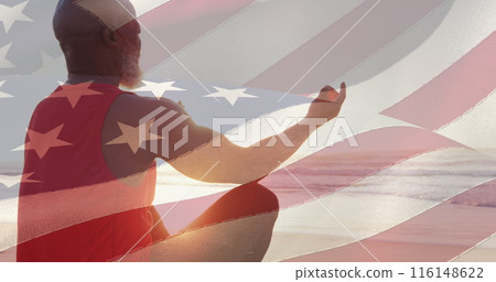 Image of flag of usa over senior african american man practicing yoga on beach 116148622