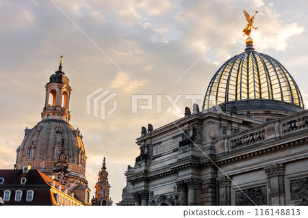Dresden symbol scenic cityscape view Frauenkirche and Albertinum Fine art academy university museum cupola golden angel statue silhouette at warm sunset warm sky. Saxony city travel destination Dresden symbol scenic cityscape view Frauenkirche and Albertinum Fine art academy university museum cupola golden angel statue silhouette at warm sunset warm sky. Saxony city travel destination 116148813