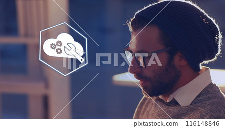 A young Caucasian professional wearing glasses, studying floating icons 116148846