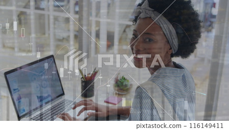 Image of multiple graphs over african american woman making report over laptop 116149411
