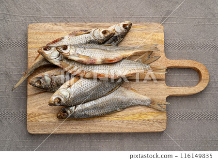 Dry roach, salted fish, dried rutilus, dehydrated vobla, taranka beer snack, whole salted arp on wood Dry roach, salted fish, dried rutilus, dehydrated vobla, taranka beer snack, whole salted arp on wood 116149835