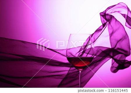 Glass of red wine on a background of waving curtain. 116151445