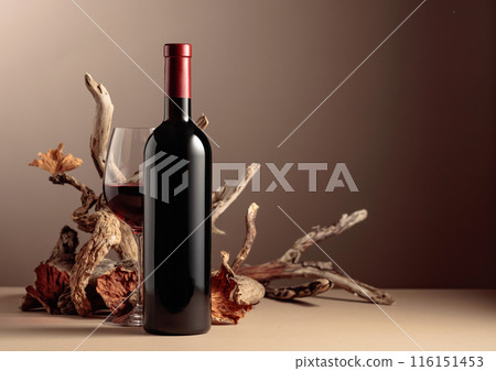 Bottle and glass of red wine with a composition of old wood. Bottle and glass of red wine with a composition of old wood. 116151453