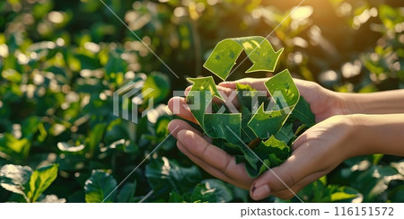 Hands holding green reduce reuse recycle symbol made from leaves on forest floor natural bokeh background. Ecological and save the earth concept. Human holding green eco icon for environment social Hands holding green reduce reuse recycle symbol made from leaves on forest floor natural bokeh background. Ecological and save the earth concept. Human holding green eco icon for environment social 116151572