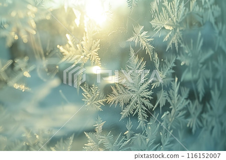 Winter frost patterns on glass. Ice crystals. Abstract light blank cold winter background or wallpaper. Frost patterns on frozen window. Frosted glass. Freezing effect. Frostwork. Harsh season. Cold 116152007