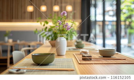 In a Japanese restaurant, a wooden table is served with pottery themed dishes 116152105