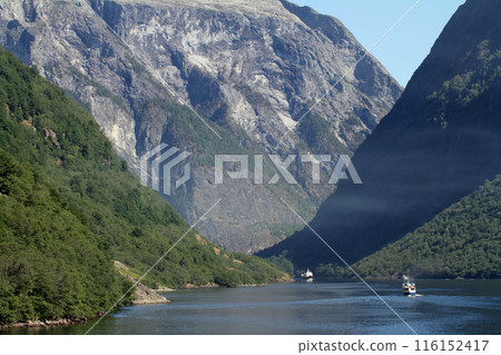 A sightseeing boat ride through the canyons of a Norwegian fjord A sightseeing boat ride through the canyons of a Norwegian fjord 116152417