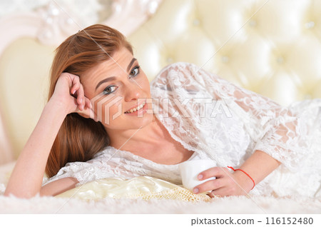 Portrait of young beautiful woman posing in bad 116152480