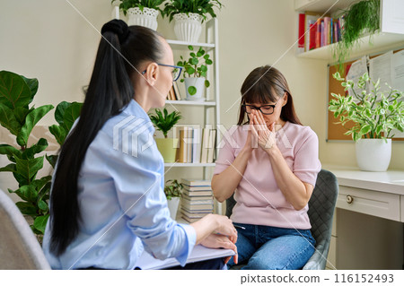 Mature sad woman in therapy session with mental professional 116152493
