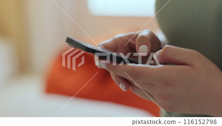 Woman using texting mobile phone or chat in home morning. Close up of young woman hand. Technology, communication concept. Woman using texting mobile phone or chat in home morning. Close up of young woman hand. Technology, communication concept. 116152798