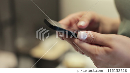 Woman using smartphone at home, typing message. Reading social media internet, typing text or shopping online. Technology, communication concept. Woman using smartphone at home, typing message. Reading social media internet, typing text or shopping online. Technology, communication concept. 116152818