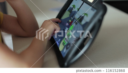 Close up of a girl hand is playing using digital computer tablet playing online games. Seven year old girl play games on TabletPC. 116152868
