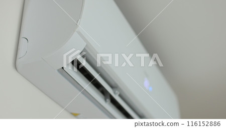 Close up of a air conditioner turning on and opening its air outlet. Modern air conditioning technologies. Close up of a air conditioner turning on and opening its air outlet. Modern air conditioning technologies. 116152886