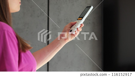 Close up woman waving her hands because of the heat and turned on the air conditioning. Modern technologies. 116152917