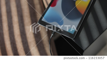 Man hand inserting a charger into a TabletPC. Charging connection to your TabletPC. 116153057