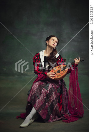 Portrait of beautiful young woman playing with a lute against vintage green background. Renaissance fairs and medieval festivals 116153124