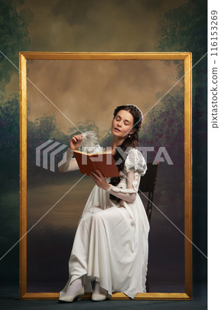 Classic literature promotion. Beautiful young woman in elegant white dress sitting in picture frame and reading book on vintage background. 116153269