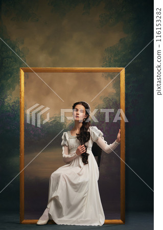 Portrait of elegant beautiful young girl in white dress sitting in golden frame against vintage background. Art-themed advertisements for galleries Portrait of elegant beautiful young girl in white dress sitting in golden frame against vintage background. Art-themed advertisements for galleries 116153282