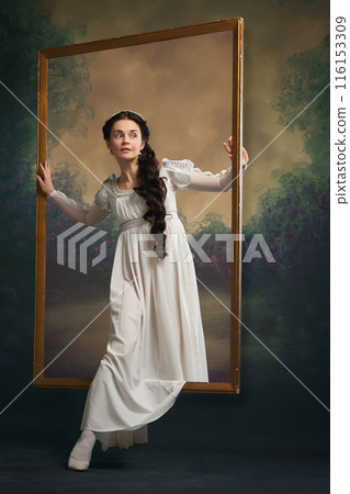 Young woman in white medieval dress stepping through golden frame against retro background. Fashion boutique poster Young woman in white medieval dress stepping through golden frame against retro background. Fashion boutique poster 116153309