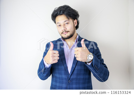 A smiling man giving a thumbs up and posing Good 116153324