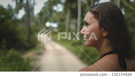 Young woman walking on tropical jungle forest road. Travel, hiking, tourism, adventure, active lifestyle. Beautiful nature landscape. Close up back view. Thailand Koh Phangan island. Young woman walking on tropical jungle forest road. Travel, hiking, tourism, adventure, active lifestyle. Beautiful nature landscape. Close up back view. Thailand Koh Phangan island. 116154889