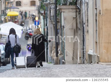 Women Traveling with Luggage in street of european city 116155545