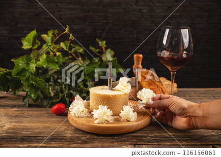 Woman slicing delicious tete de moine cheese 116156061