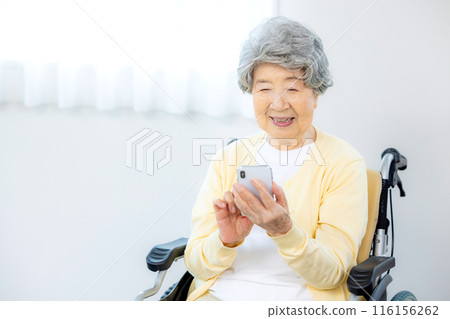 Senior woman in a wheelchair operating a smartphone 116156262