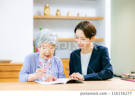 Senior businesswoman writing end-of-life notebook 116156277