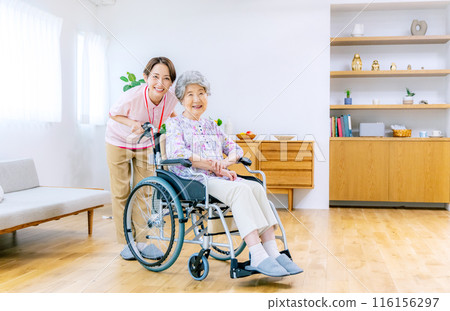 Elderly person in a wheelchair and a caregiver 116156297
