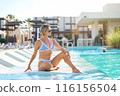 A girl sits near the pool after spa treatments. Turkey, hotel, vacation, travel, girl in a swimsuit 116156504