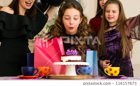 Girl blowing out birthday candles 116157673