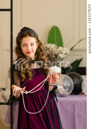 Girl holding pearls and smiling 116157674