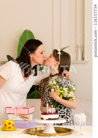 Mother and daughter sharing kiss during birthday celebration 116157734