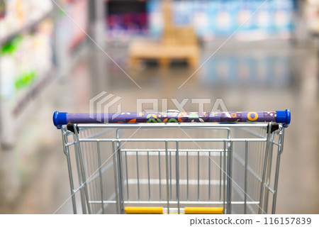 Abstract blurry photo of a supermarket with an empty shopping cart concept. Abstract blurry photo of a supermarket with an empty shopping cart concept. 116157839