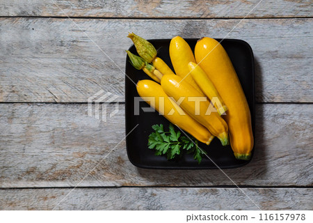Slicing zucchini on a cutting board. Ripe zucchini on a gray background. Top view, horizontal. 116157978