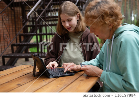 A teenage girl and an older woman spend time together. A teenage girl and an older woman spend time together. 116157994