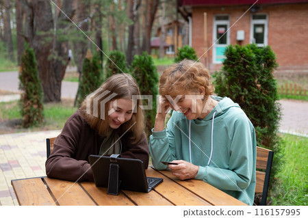 A teenage girl and an older woman spend time together. 116157995