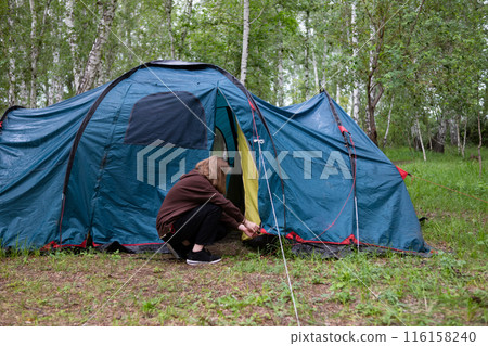 A woman sets up a tent in the forest. Journeys. 116158240