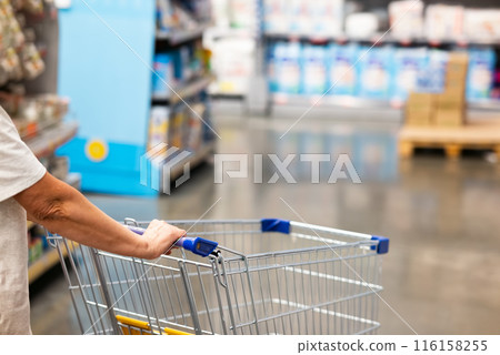 Abstract blurry photo of a supermarket with an empty shopping cart concept. Abstract blurry photo of a supermarket with an empty shopping cart concept. 116158255