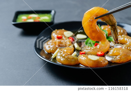Pickled shrimp with chopstick Soy Sauce, chilli and garlic on stone background, 116158318